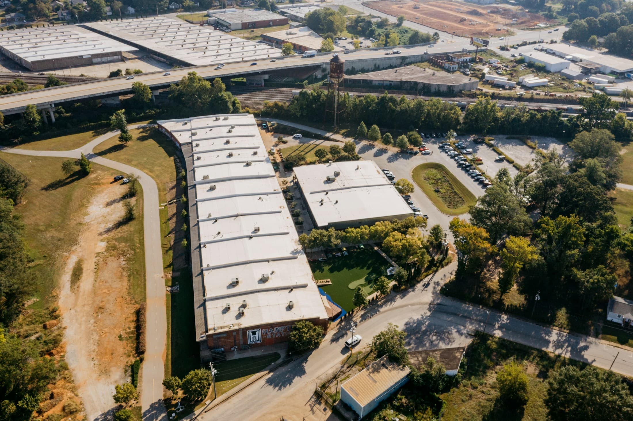 Aerial view of commercial buildings with flat white roofs and surrounding parking